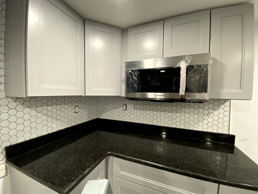renovated narrow kitchen showing vertical storage and light color scheme